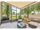 Relaxing screened-in patio with comfortable wicker furniture, providing a serene outdoor space at 6974 Holly Heath Dr, Riverview, FL 33578