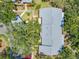 Overhead view of a well-maintained home with mature tree canopy, lush lawn and gray roof at 70 Cypress Pl, Oldsmar, FL 34677