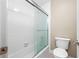 Bathroom with a shower and tub combination and toilet. The shower has glass sliding doors at 70 Cypress Pl, Oldsmar, FL 34677