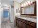 Bathroom with granite countertops, wood cabinets, a large mirror and views of the Primary bedroom at 70 Cypress Pl, Oldsmar, FL 34677