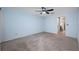 Spacious bedroom with neutral carpet, a ceiling fan, and an ensuite bathroom entrance at 70 Cypress Pl, Oldsmar, FL 34677