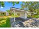 Open carport featuring a storage room and ample parking space surrounded by lush landscaping at 70 Cypress Pl, Oldsmar, FL 34677