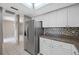 Bright kitchen with stainless steel refrigerator, white cabinetry, and a tiled backsplash at 70 Cypress Pl, Oldsmar, FL 34677