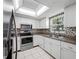 Well-lit kitchen with white cabinets, stainless steel appliances, mosaic backsplash, and bright window at 70 Cypress Pl, Oldsmar, FL 34677
