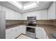 Kitchen showcasing stainless steel oven and microwave with shaker cabinets and tile backsplash at 70 Cypress Pl, Oldsmar, FL 34677