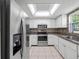 Bright kitchen featuring modern stainless steel appliances, white cabinetry, and a tiled backsplash at 70 Cypress Pl, Oldsmar, FL 34677