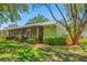 View of the rear of the home featuring a screened in lanai, mature trees and lush lawn at 70 Cypress Pl, Oldsmar, FL 34677