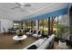 Bright sunroom has large windows, carpeting, ceiling fans, and plenty of seating at 70 Cypress Pl, Oldsmar, FL 34677