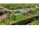 Aerial shot of modern home with dark roof and lush backyard, adjacent to canal and nearby green space at 7054 Rosemont Dr, Englewood, FL 34224