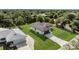 An aerial view reveals a cozy home with a river at the back and driveway at the front, surrounded by lush greenery at 7054 Rosemont Dr, Englewood, FL 34224
