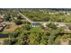 An aerial view of a modern home situated on a green lot, surrounded by lush trees and a water canal at 7054 Rosemont Dr, Englewood, FL 34224