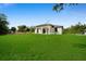Well-maintained backyard featuring lush green grass and modern architecture at 7054 Rosemont Dr, Englewood, FL 34224