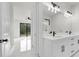 Bathroom view into a bright bedroom with black-framed sliding glass door and a double vanity at 7054 Rosemont Dr, Englewood, FL 34224