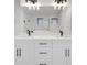 Bathroom featuring double vanity with white cabinets, black hardware, and a large mirror at 7054 Rosemont Dr, Englewood, FL 34224