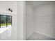Bright bedroom with black-framed sliding glass door, a ceiling fan and view into the closet at 7054 Rosemont Dr, Englewood, FL 34224