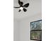 Bright bedroom featuring a ceiling fan and a black-framed window with a view of surrounding trees at 7054 Rosemont Dr, Englewood, FL 34224