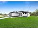 Charming one-story home boasts a paved driveway, a two-car garage, and a lush green lawn at 7054 Rosemont Dr, Englewood, FL 34224