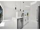 Modern kitchen with stainless steel appliances, a white island, and sleek pendant lighting above at 7054 Rosemont Dr, Englewood, FL 34224
