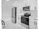 Modern kitchen showcasing stainless steel appliances, sleek hardware, and white countertops and cabinets at 7054 Rosemont Dr, Englewood, FL 34224