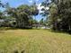 Large backyard with a grassy lawn and mature trees, offering privacy and natural beauty at 708 Keeling St, Brooksville, FL 34601