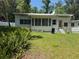Backyard view with lots of green space and the home's exterior and windows at 708 Keeling St, Brooksville, FL 34601
