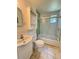 This bathroom features a toilet, sink, storage cabinet, and shower with glass doors at 708 Keeling St, Brooksville, FL 34601