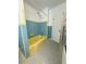 This bathroom features original blue and yellow tiling, a shower head and access to a closet at 708 Keeling St, Brooksville, FL 34601