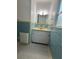Bathroom with original blue and yellow tiling, a white vanity, and mosaic tile flooring at 708 Keeling St, Brooksville, FL 34601