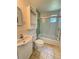 This bathroom features a toilet, sink, storage cabinet, and shower with glass doors at 708 Keeling St, Brooksville, FL 34601