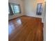 Bright bedroom with wood floors, two windows with curtains and neutral paint at 708 Keeling St, Brooksville, FL 34601