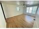 Bright bedroom featuring wood-look flooring, a ceiling fan, and natural light from two windows at 708 Keeling St, Brooksville, FL 34601
