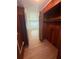 Wood-paneled closet with a window and open doors next to a bedroom with wood-look flooring at 708 Keeling St, Brooksville, FL 34601