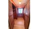 Wood-paneled closet featuring shelves, a window, a wooden floor, and bifold doors at 708 Keeling St, Brooksville, FL 34601