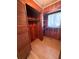 Wood-paneled closet featuring shelves, a window, a wooden floor, and bifold doors at 708 Keeling St, Brooksville, FL 34601