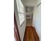 Hallway with wood floors leading to a kitchen featuring white appliances at 708 Keeling St, Brooksville, FL 34601