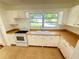 Bright kitchen featuring laminate counters, white cabinetry and neutral tile floors at 708 Keeling St, Brooksville, FL 34601