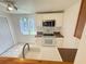 The kitchen features white cabinets, a stainless steel microwave, and a window letting in plenty of natural light at 708 Keeling St, Brooksville, FL 34601