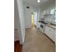 View of kitchen with neutral tile flooring, white cabinets, and pass-through to hallway at 708 Keeling St, Brooksville, FL 34601