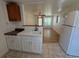 This kitchen flows into the living room and features a white refrigerator, tile flooring, and white paneled walls at 708 Keeling St, Brooksville, FL 34601