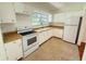 Well-lit kitchen featuring white cabinets, laminate countertops, and modern appliances at 708 Keeling St, Brooksville, FL 34601