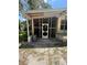 View of the screened-in porch showing the front door and concrete flooring at 708 Keeling St, Brooksville, FL 34601