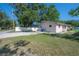 View of back exterior of the house with a long driveway and partially fenced yard at 725 2Nd Ne Ave, Largo, FL 33770