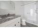A modern bathroom featuring granite countertops and a sleek, glass-enclosed shower at 725 2Nd Ne Ave, Largo, FL 33770