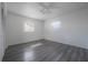 A well-lit bedroom with two windows, gray wood-look flooring, and a ceiling fan at 725 2Nd Ne Ave, Largo, FL 33770