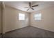 A carpeted bedroom with a ceiling fan and two windows, offering natural light at 725 2Nd Ne Ave, Largo, FL 33770