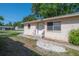 Beige single-story home with a concrete walkway and a white front door at 725 2Nd Ne Ave, Largo, FL 33770