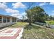 Spacious backyard with mature trees and a concrete patio at 7810 Pineapple Ln, Port Richey, FL 34668