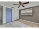 Well-lit bedroom with light-colored tile flooring, a closet, and a ceiling fan at 7810 Pineapple Ln, Port Richey, FL 34668