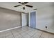 Cozy bedroom featuring tile floors, blue closet, and a ceiling fan at 7810 Pineapple Ln, Port Richey, FL 34668