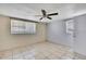 Bedroom with two large windows and tile flooring, featuring a ceiling fan at 7810 Pineapple Ln, Port Richey, FL 34668